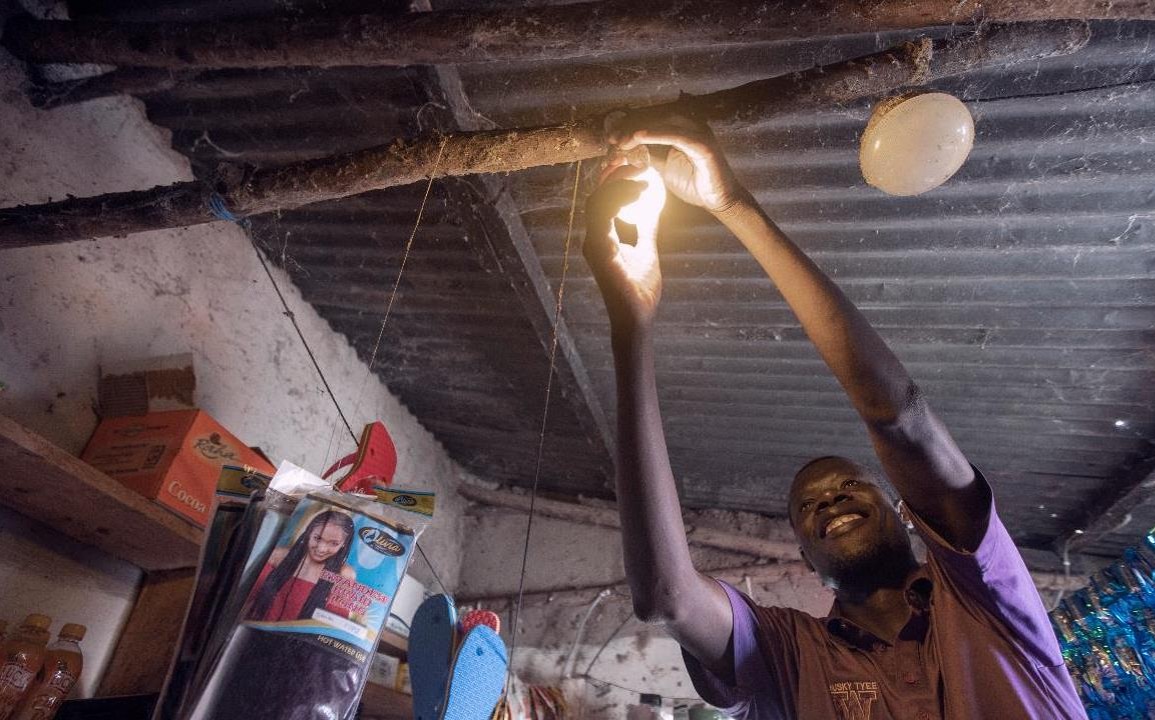 Smiling man installing a lightbulb