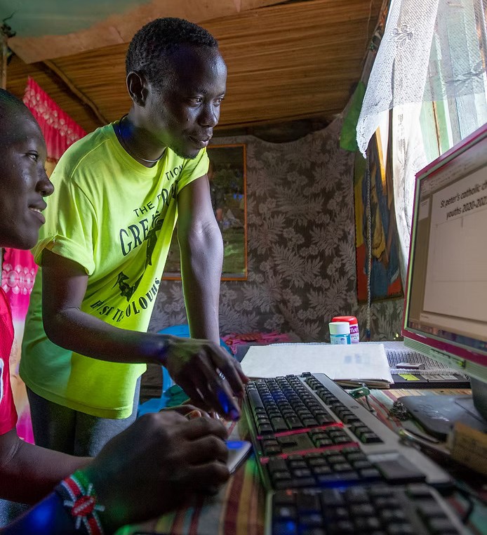 Teacher instructs a student how to use a computer