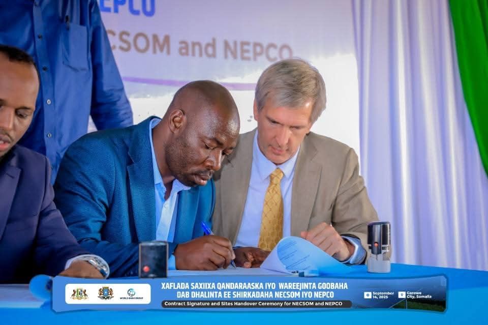 Two men at a table signing a contract